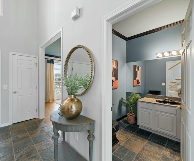 bathroom with vanity, a towering ceiling, and crown molding