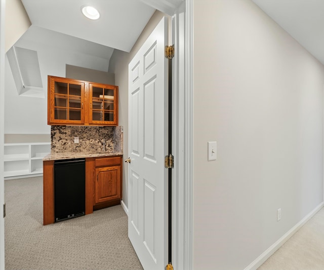 bar with light colored carpet, backsplash, and refrigerator