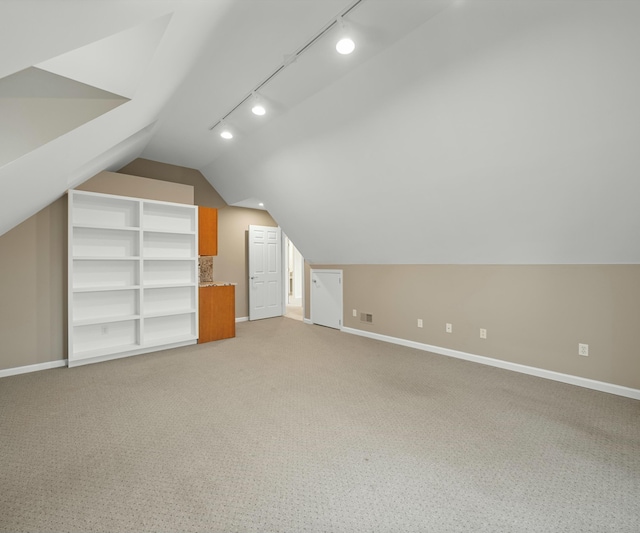 additional living space with light colored carpet and lofted ceiling