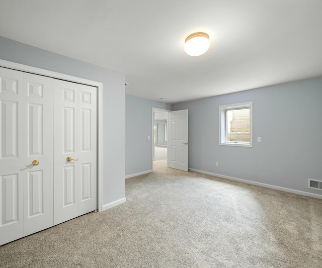 unfurnished bedroom featuring a closet and light carpet