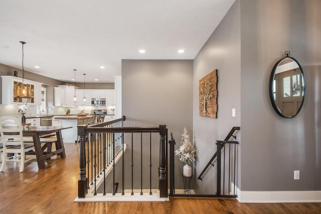 staircase featuring sink and hardwood / wood-style floors