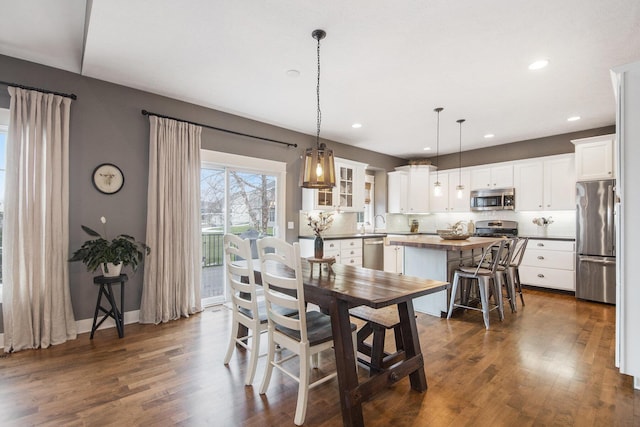 dining area featuring sink and dark wood-type flooring