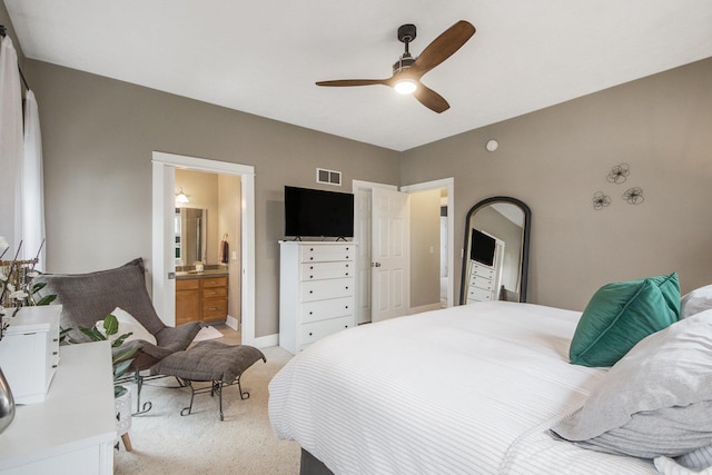 carpeted bedroom featuring ceiling fan and ensuite bath