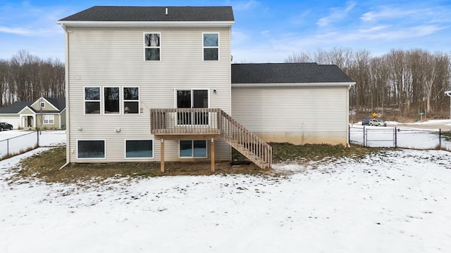 snow covered house with a wooden deck