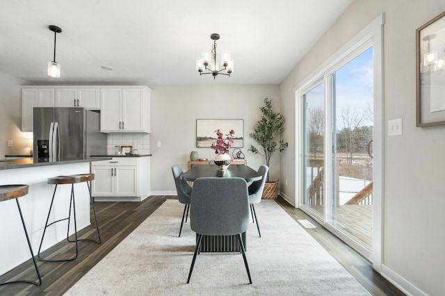 dining space with a notable chandelier and dark hardwood / wood-style flooring