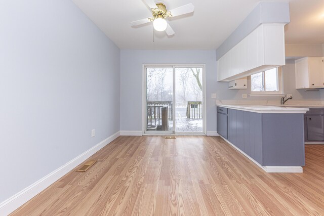 kitchen featuring white cabinetry, ceiling fan, and light wood-type flooring