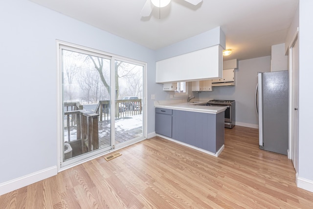 kitchen with stainless steel appliances, white cabinetry, sink, and light wood-type flooring