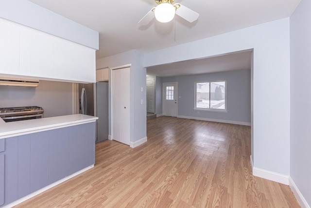 kitchen with stainless steel appliances, ceiling fan, gray cabinetry, and light hardwood / wood-style floors