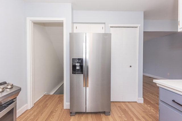 kitchen featuring white cabinetry, stainless steel fridge, and light hardwood / wood-style flooring