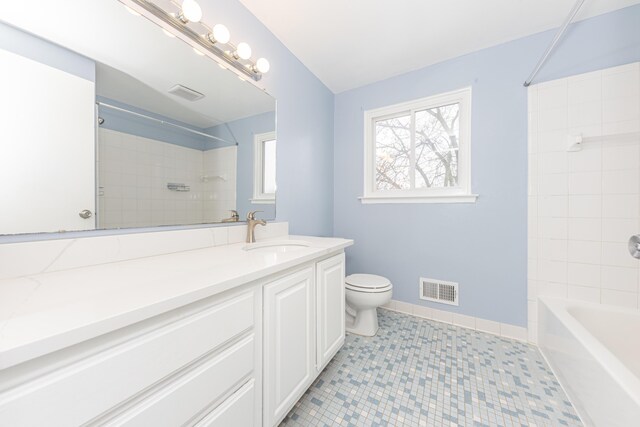 full bathroom with vanity, tile patterned flooring, tiled shower / bath combo, and toilet