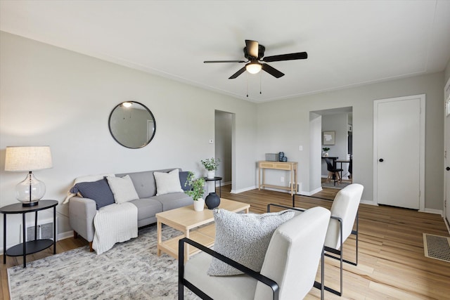 living room with ceiling fan and light wood-type flooring