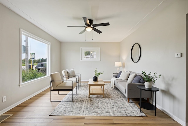 living room with a healthy amount of sunlight, ceiling fan, and light hardwood / wood-style flooring