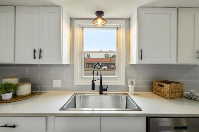 kitchen featuring white cabinetry, sink, decorative backsplash, and dishwasher