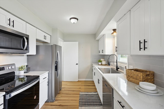 kitchen with sink, white cabinets, and appliances with stainless steel finishes