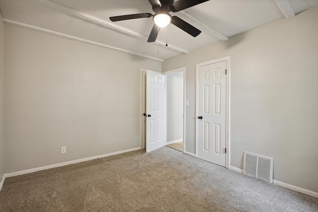 empty room featuring ceiling fan, beam ceiling, and carpet floors