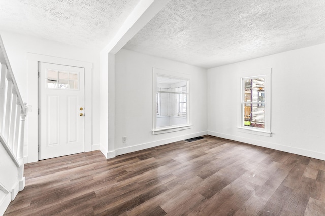 foyer featuring a textured ceiling and dark hardwood / wood-style flooring