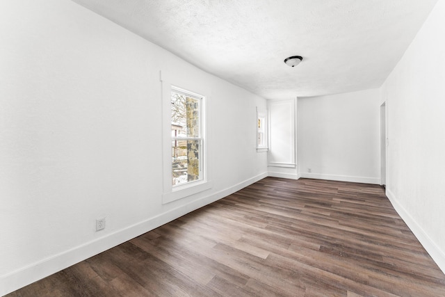 unfurnished room with dark hardwood / wood-style floors and a textured ceiling