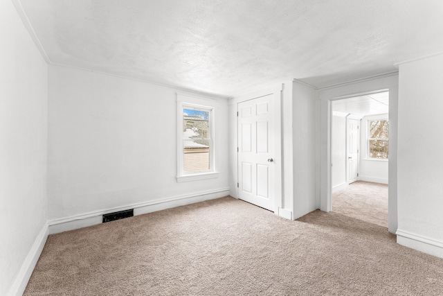 unfurnished bedroom featuring light colored carpet and a textured ceiling