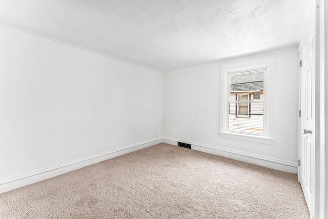 carpeted spare room featuring a textured ceiling