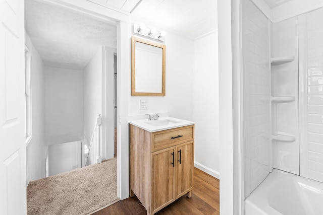 bathroom with hardwood / wood-style flooring, vanity, and  shower combination