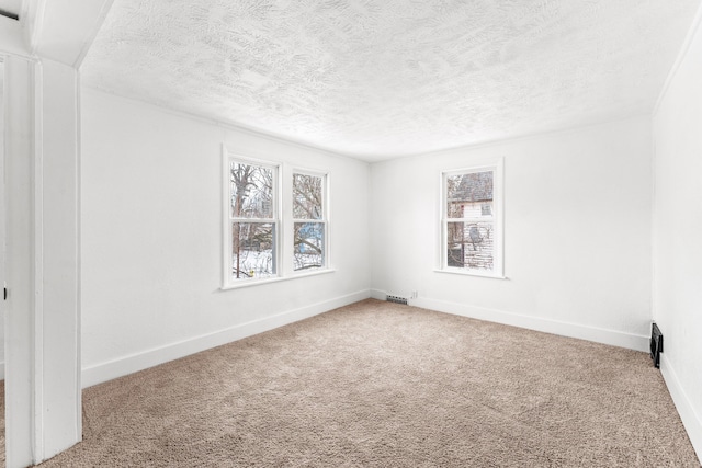 carpeted spare room with a textured ceiling