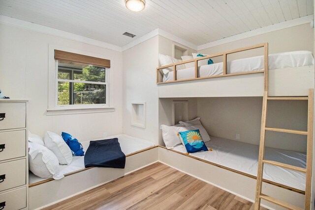 unfurnished bedroom with crown molding, wood ceiling, and wood-type flooring