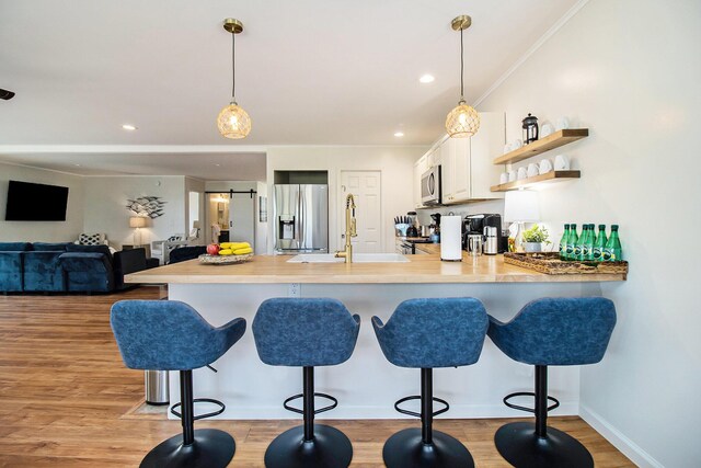 kitchen with hanging light fixtures, stainless steel appliances, and a kitchen breakfast bar