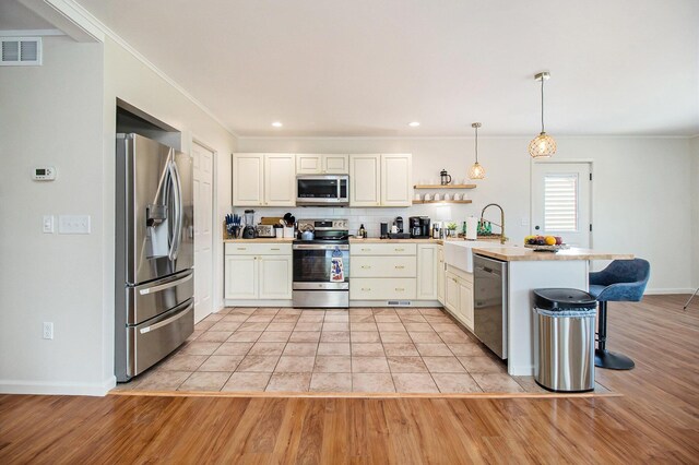 kitchen featuring hanging light fixtures, a kitchen breakfast bar, kitchen peninsula, stainless steel appliances, and decorative backsplash