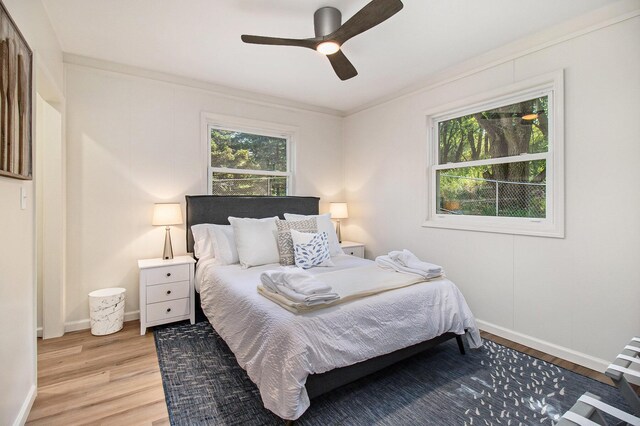 bedroom with ornamental molding, hardwood / wood-style floors, and ceiling fan