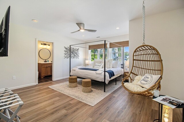 bedroom with hardwood / wood-style flooring, ceiling fan, and ensuite bath