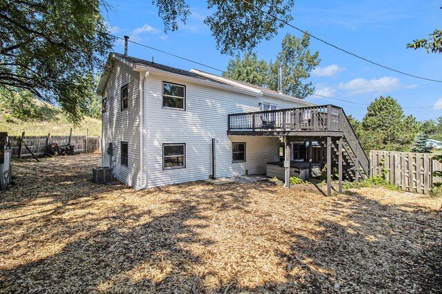 rear view of house featuring central AC unit and a deck