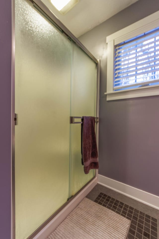 bathroom featuring a shower with shower door and tile patterned floors