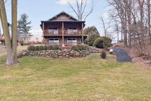 rear view of property with a wooden deck and a lawn