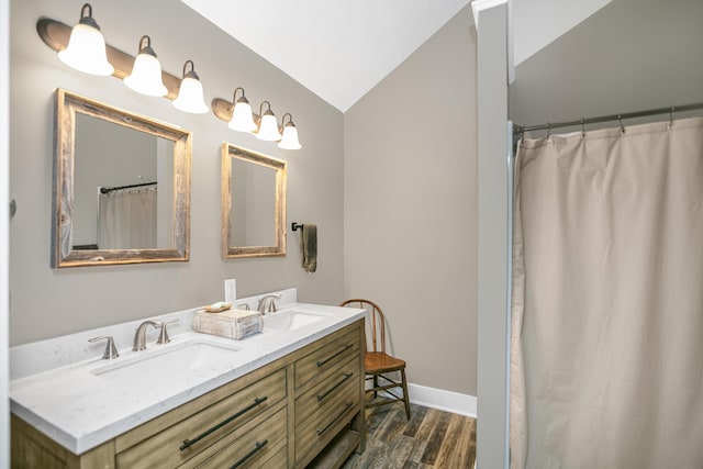 bathroom featuring hardwood / wood-style flooring, vanity, a shower with curtain, and vaulted ceiling