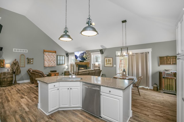 kitchen featuring white cabinetry, dishwasher, a brick fireplace, and sink