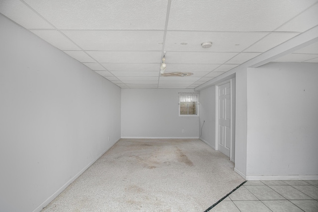 empty room with light colored carpet and a drop ceiling