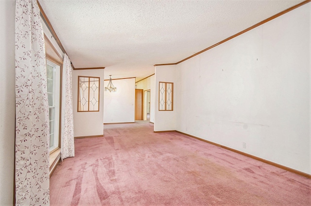 empty room with carpet floors, ornamental molding, and a textured ceiling