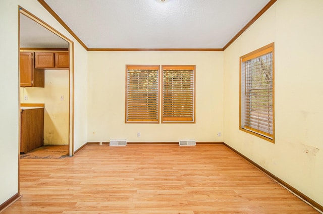 unfurnished room with ornamental molding, light hardwood / wood-style flooring, and a textured ceiling