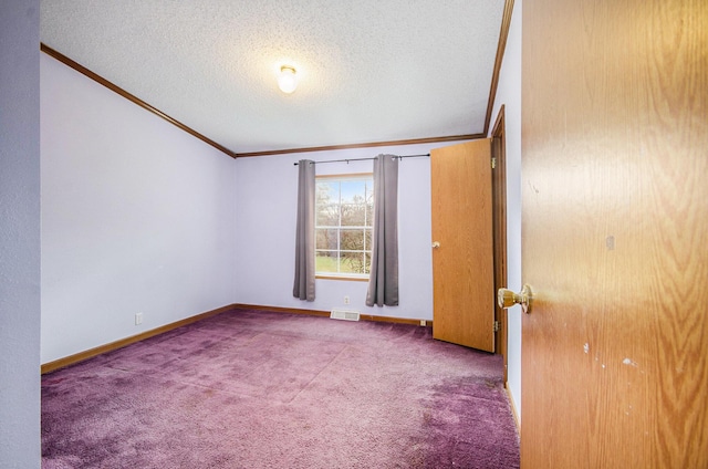 carpeted empty room featuring ornamental molding and a textured ceiling