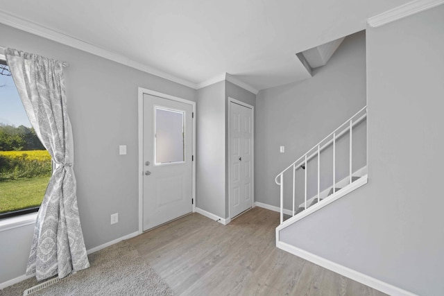 foyer with crown molding and light hardwood / wood-style floors