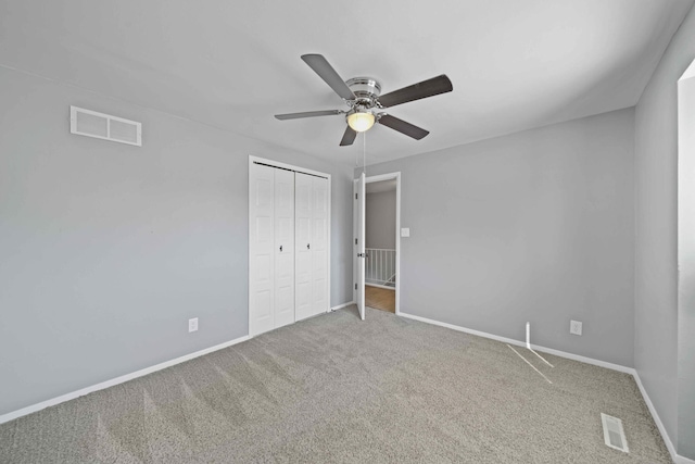 unfurnished bedroom with ceiling fan, carpet floors, and a closet