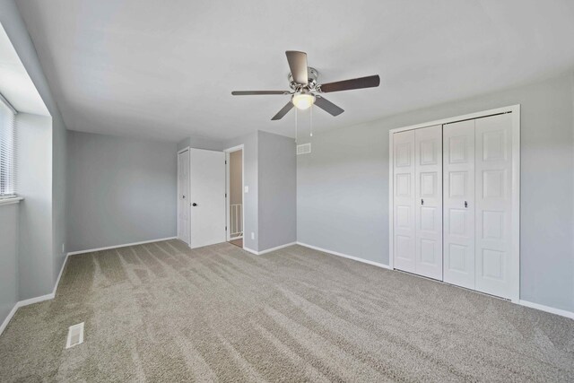 unfurnished bedroom with ceiling fan, a closet, and light carpet