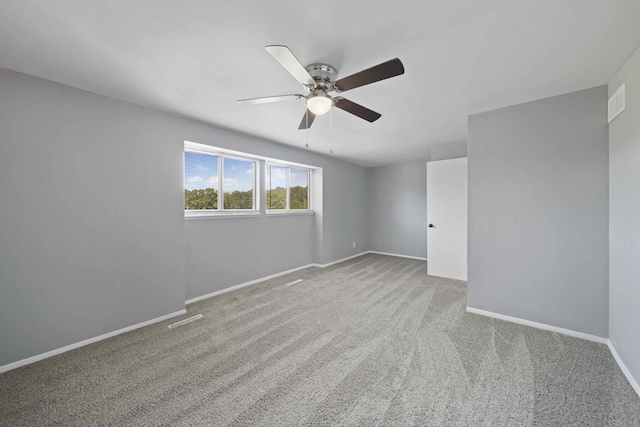 carpeted spare room featuring ceiling fan