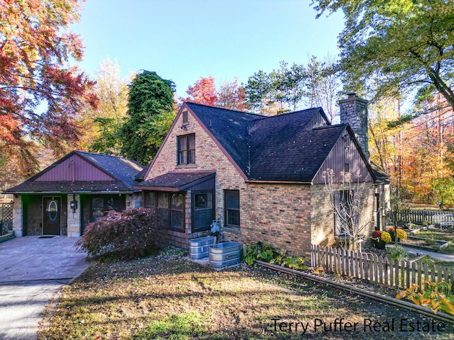 tudor-style house featuring a front yard