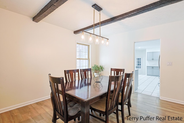 dining space with beam ceiling and hardwood / wood-style flooring