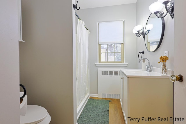 bathroom with toilet, radiator heating unit, vanity, a shower with shower curtain, and hardwood / wood-style flooring