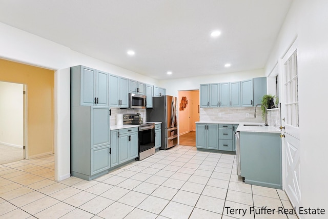 kitchen featuring sink, light tile patterned floors, stainless steel appliances, and decorative backsplash