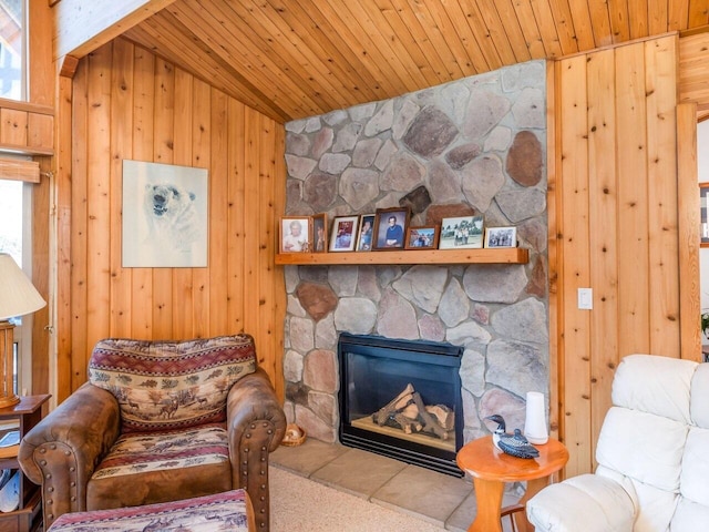 sitting room with wooden walls, a fireplace, lofted ceiling, plenty of natural light, and wooden ceiling