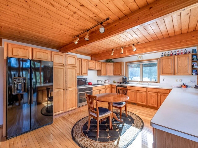 kitchen featuring beamed ceiling, black appliances, sink, wood ceiling, and light hardwood / wood-style floors