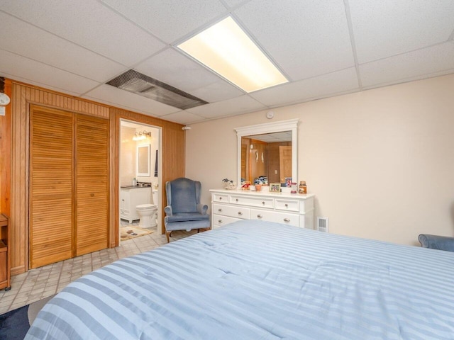 bedroom with ensuite bath and a paneled ceiling